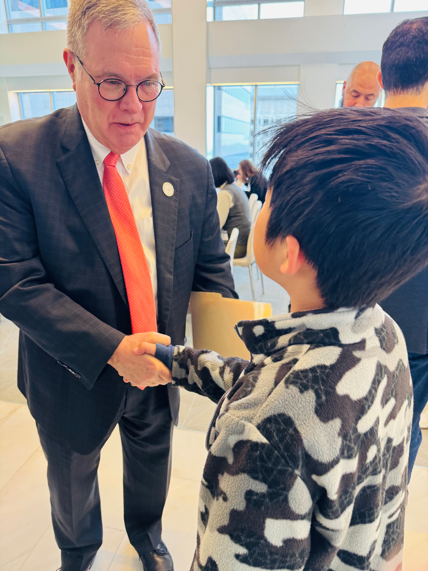 Governor Bob Ferguson greeting a young attendee at Northwest Quantum Day.